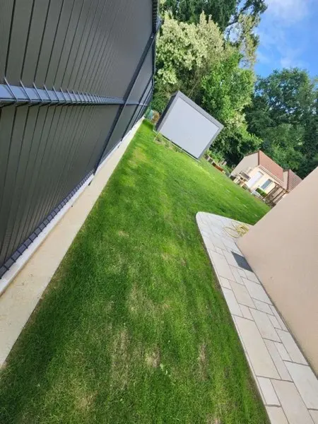 Pelouse neuve avec terrasse pavée créée par ALP Jardin en Essonne